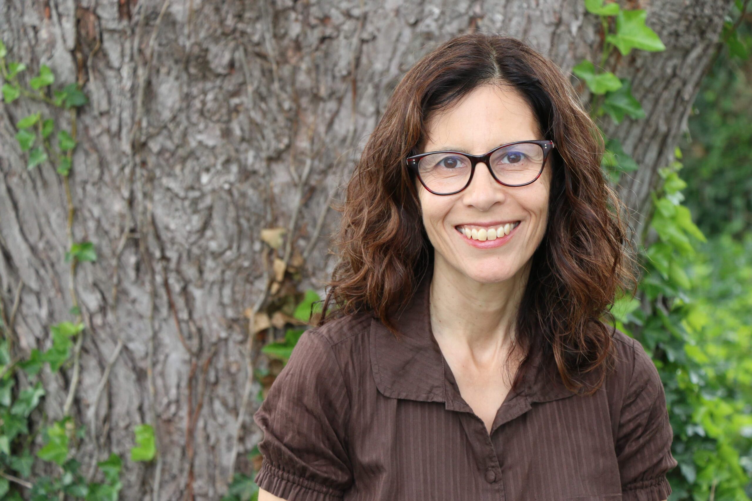 Dr. Valerie Mendoza, headshot, standing in front of a tree