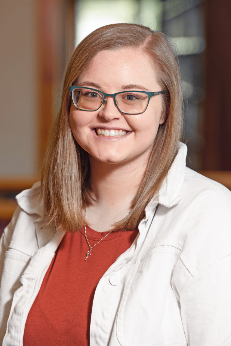 Headshot of a young woman with shoulder-length blonde hair wearing glasses